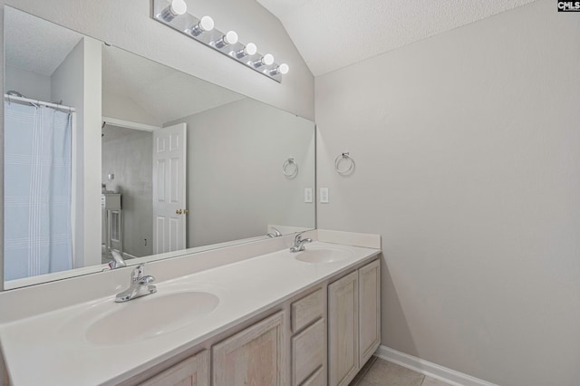 bathroom featuring vaulted ceiling, a textured ceiling, vanity, and tile patterned flooring