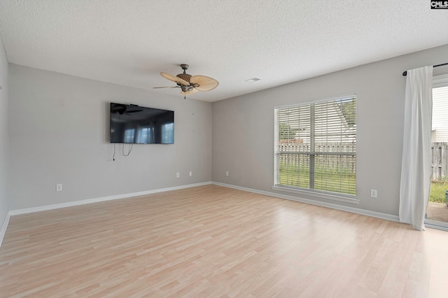 spare room with a textured ceiling, ceiling fan, and light hardwood / wood-style floors