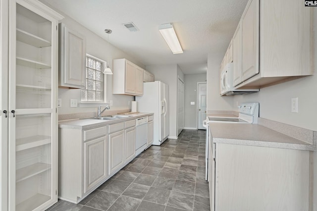 kitchen with white cabinetry, white appliances, and sink