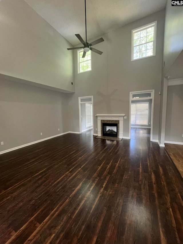 unfurnished living room with high vaulted ceiling, dark hardwood / wood-style floors, a textured ceiling, and ceiling fan