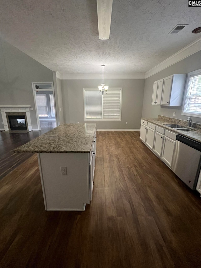 kitchen featuring a notable chandelier, white cabinetry, a center island, hanging light fixtures, and stainless steel dishwasher