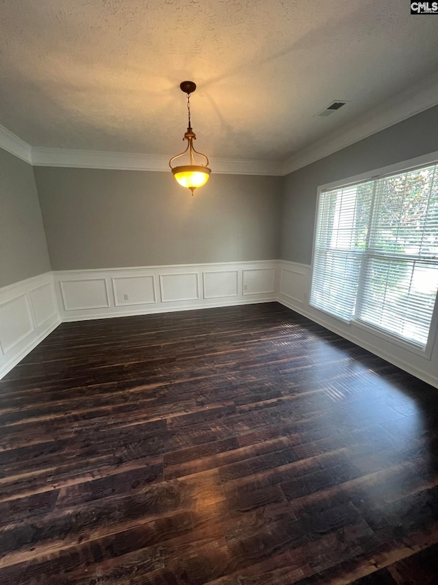 empty room with dark hardwood / wood-style flooring, crown molding, and a textured ceiling