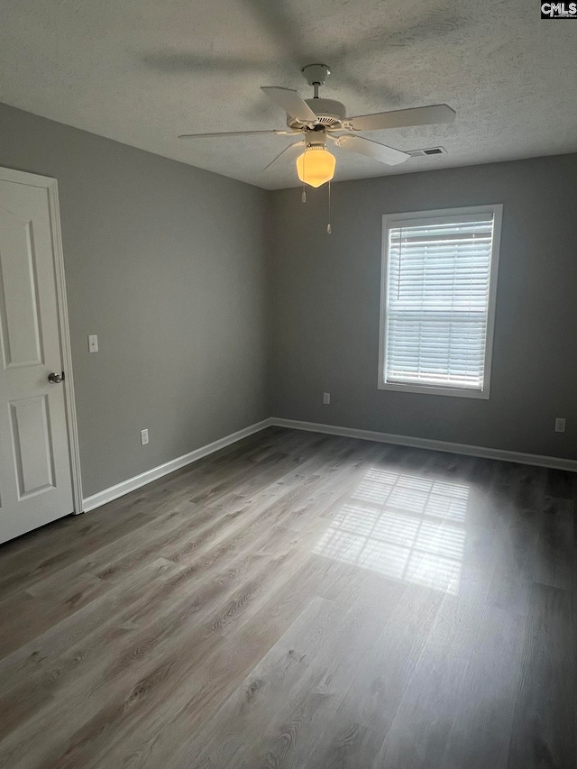 unfurnished room with a textured ceiling, light hardwood / wood-style flooring, and ceiling fan