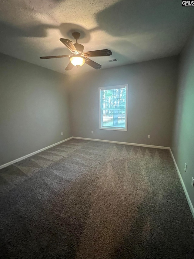 carpeted spare room featuring a textured ceiling and ceiling fan