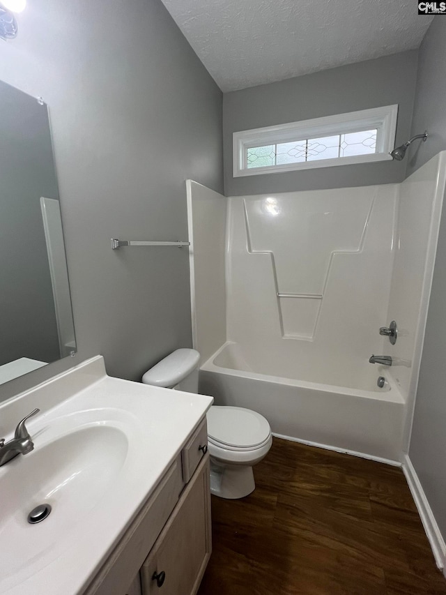 full bathroom with shower / bathtub combination, hardwood / wood-style floors, toilet, vanity, and a textured ceiling