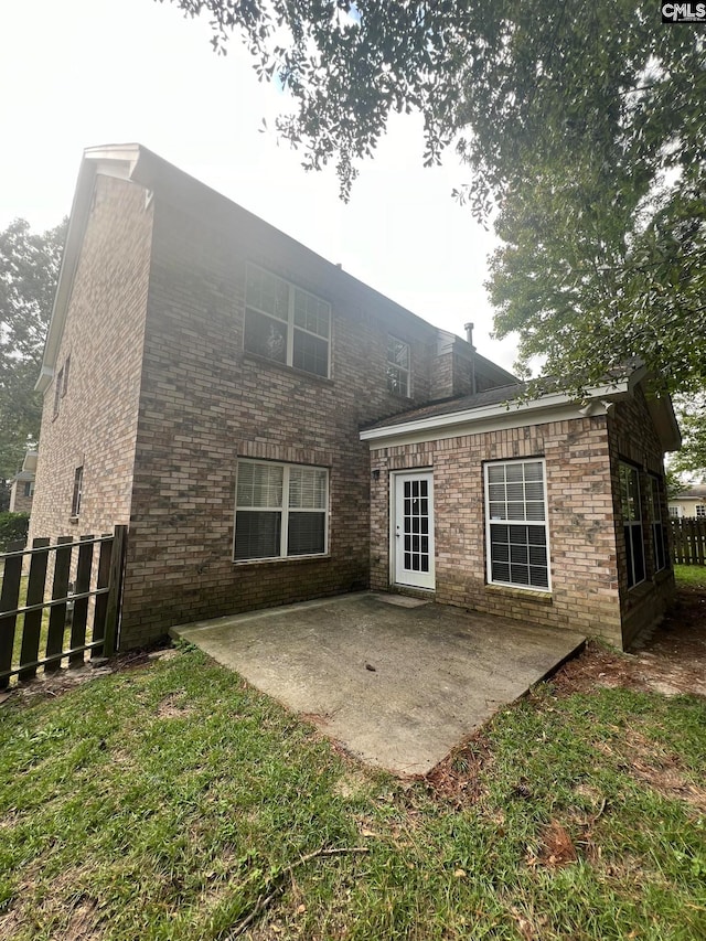 rear view of house with a yard and a patio area