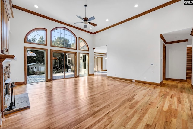 unfurnished living room featuring a fireplace, light wood-type flooring, crown molding, and ceiling fan