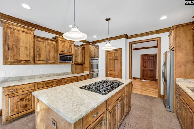 kitchen with pendant lighting, crown molding, a center island, light stone countertops, and appliances with stainless steel finishes