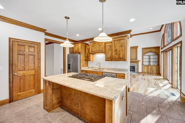 kitchen featuring a center island, crown molding, appliances with stainless steel finishes, light hardwood / wood-style floors, and pendant lighting