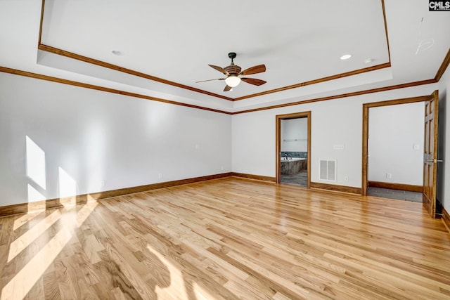 unfurnished living room with ornamental molding, light hardwood / wood-style flooring, a tray ceiling, and ceiling fan