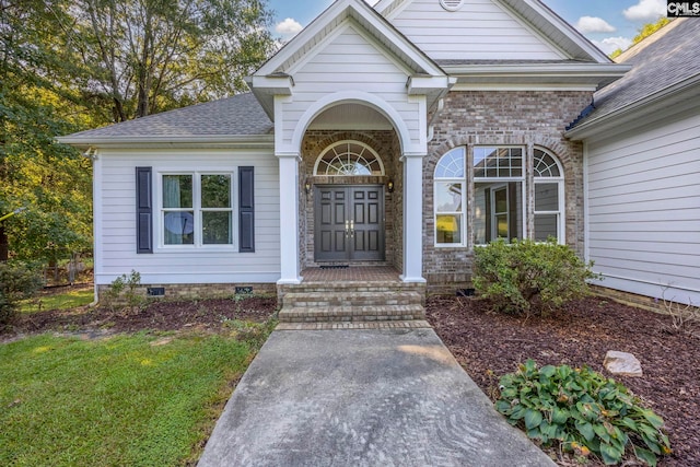 view of exterior entry with a yard