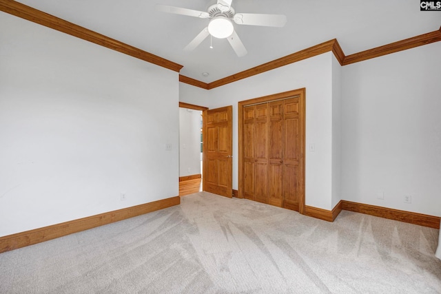 unfurnished bedroom featuring crown molding, carpet floors, ceiling fan, and a closet