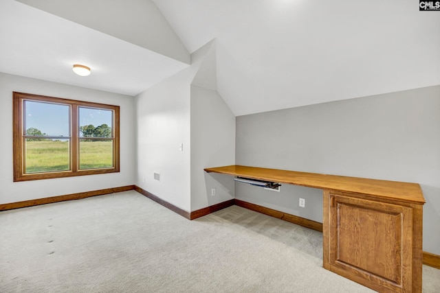 bonus room featuring light carpet, lofted ceiling, and built in desk