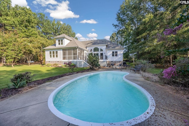 view of swimming pool with a yard and a sunroom