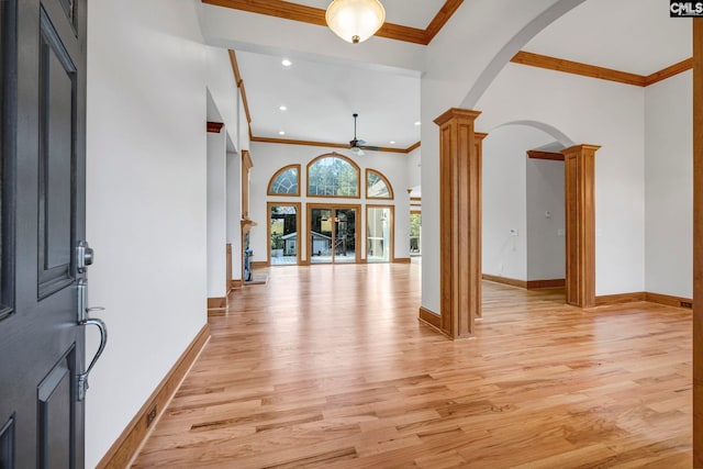 entrance foyer with crown molding, light hardwood / wood-style flooring, ornate columns, and ceiling fan