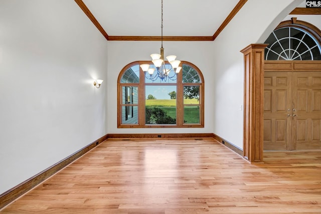 interior space featuring crown molding, an inviting chandelier, and light hardwood / wood-style floors