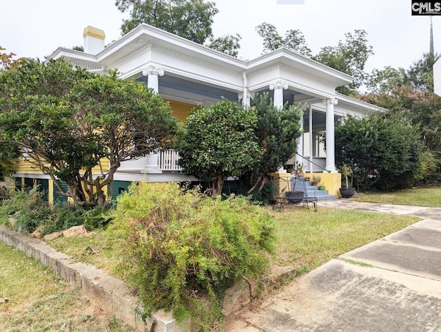 greek revival inspired property featuring a front lawn