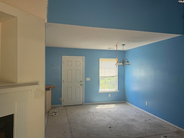 interior space featuring a fireplace, a textured ceiling, a chandelier, and light colored carpet