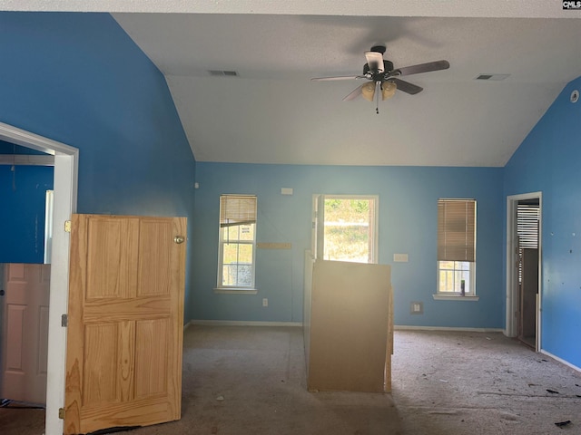 carpeted spare room with lofted ceiling, ceiling fan, and a textured ceiling