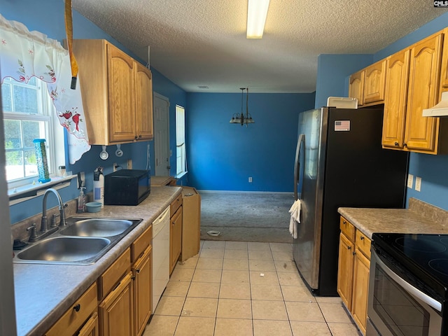 kitchen with a textured ceiling, dishwasher, sink, hanging light fixtures, and ventilation hood