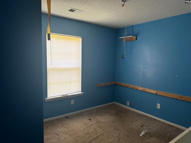 carpeted empty room featuring a textured ceiling