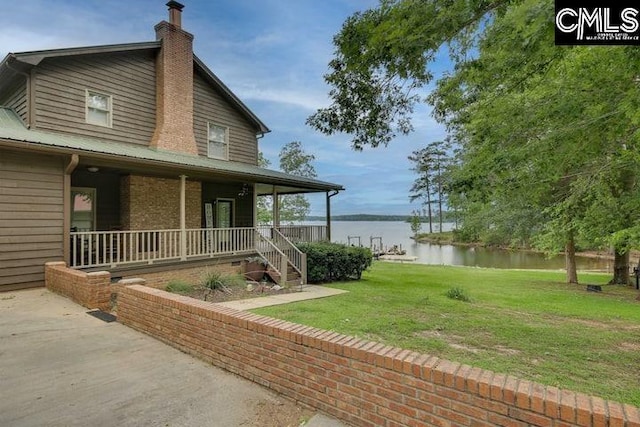 exterior space with covered porch, a water view, and a lawn