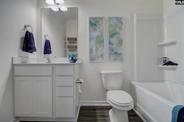 bathroom featuring hardwood / wood-style floors, vanity, toilet, and a washtub