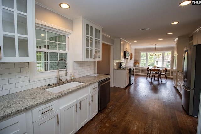 kitchen featuring decorative light fixtures, appliances with stainless steel finishes, white cabinets, and decorative backsplash