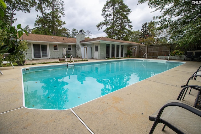 view of swimming pool with an outbuilding and a patio