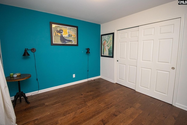 unfurnished bedroom featuring a closet and dark hardwood / wood-style floors