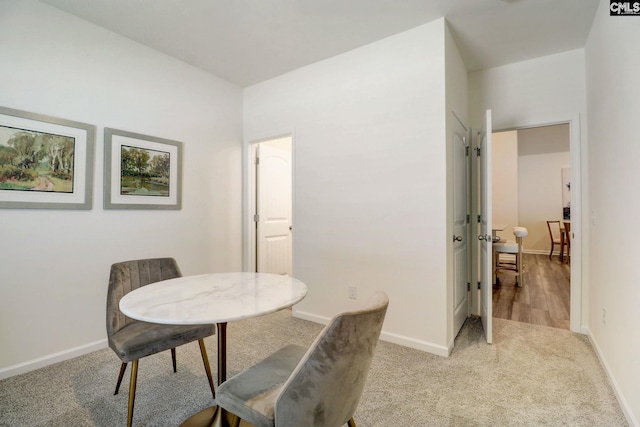 dining space featuring light carpet