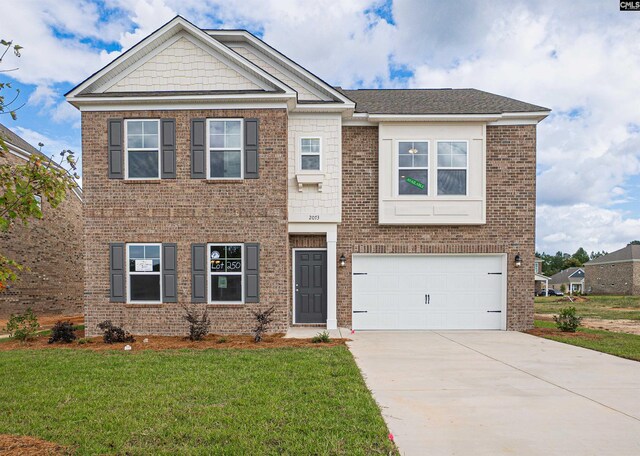 view of front of home with a front lawn and a garage