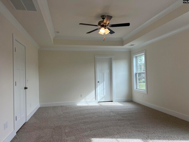 spare room featuring a tray ceiling, carpet, and ceiling fan