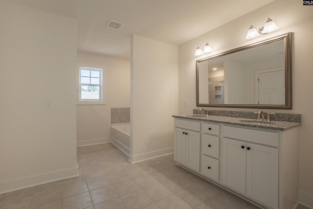 bathroom with vanity, a bath, and tile patterned floors