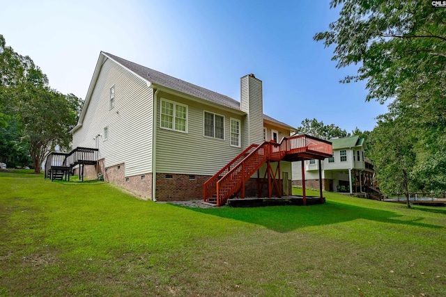 rear view of house with a lawn and a wooden deck