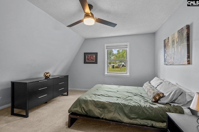 bedroom featuring ceiling fan, light colored carpet, a textured ceiling, and vaulted ceiling