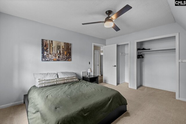 bedroom featuring a textured ceiling, ceiling fan, and light colored carpet