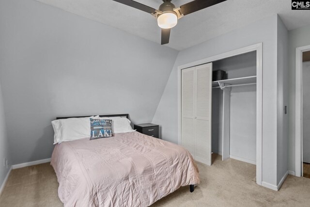 bedroom featuring ceiling fan, light colored carpet, a textured ceiling, and vaulted ceiling