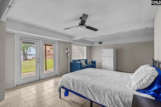 tiled bedroom featuring ceiling fan, white refrigerator, access to outside, and a textured ceiling