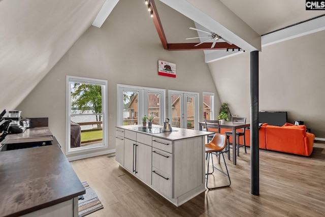 kitchen featuring ceiling fan, white cabinets, sink, french doors, and light hardwood / wood-style flooring