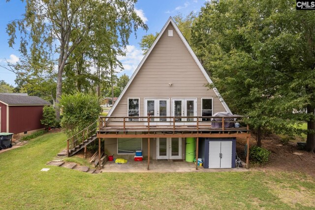 back of house featuring a lawn, a wooden deck, and french doors