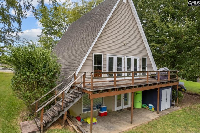 back of house featuring a lawn, a deck, a patio area, and french doors