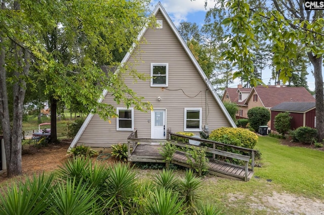 rear view of house featuring a deck and a yard