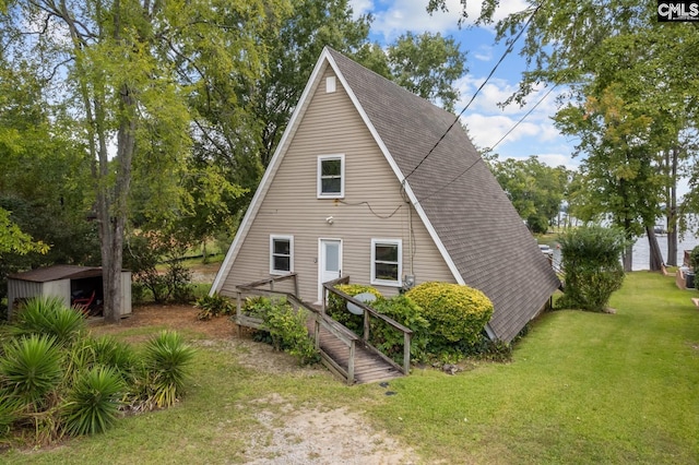 view of front of property featuring a front lawn and a shed