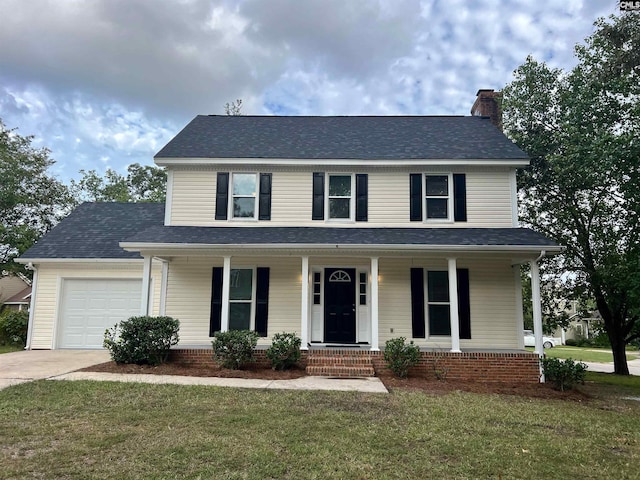 view of front of home with a garage, a front lawn, and covered porch