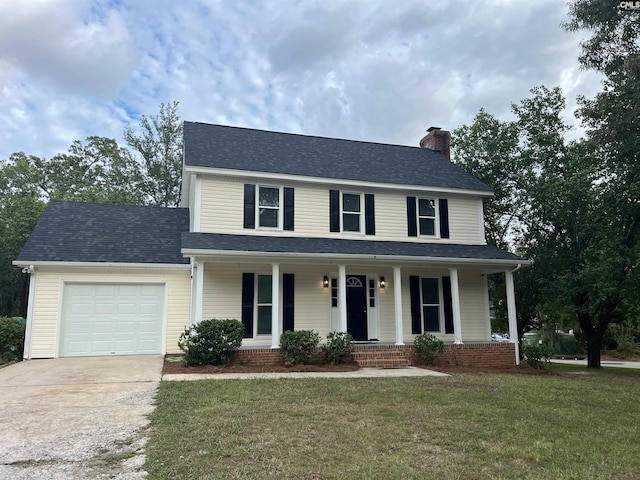 view of front facade with a garage, a front lawn, and covered porch