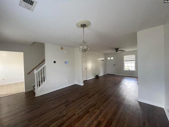 unfurnished living room featuring dark wood-type flooring and ceiling fan with notable chandelier