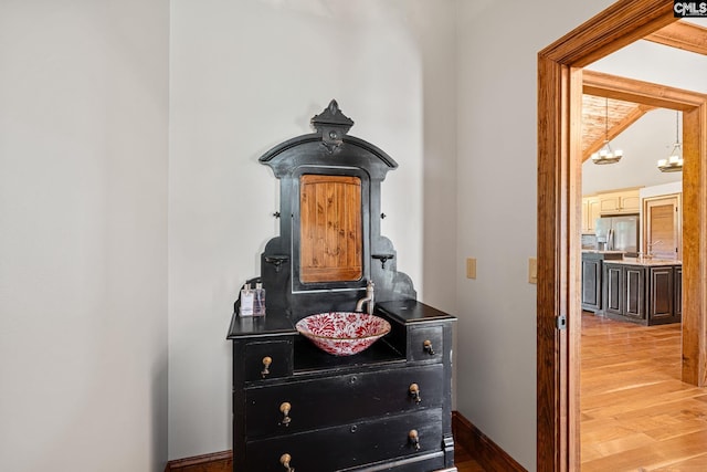 details featuring hardwood / wood-style flooring and stainless steel fridge