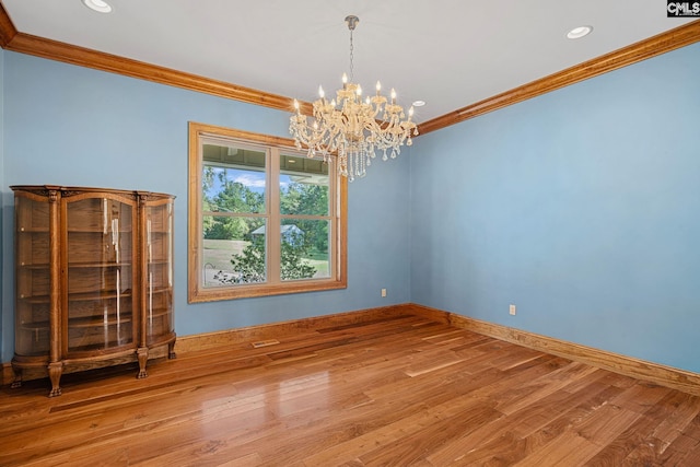 unfurnished room featuring light hardwood / wood-style floors, ornamental molding, and a notable chandelier