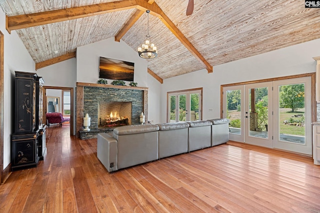 living room featuring a stone fireplace, light wood-type flooring, beam ceiling, and high vaulted ceiling